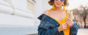 mulher posando pra foto com look de vestido com jaqueta jeans